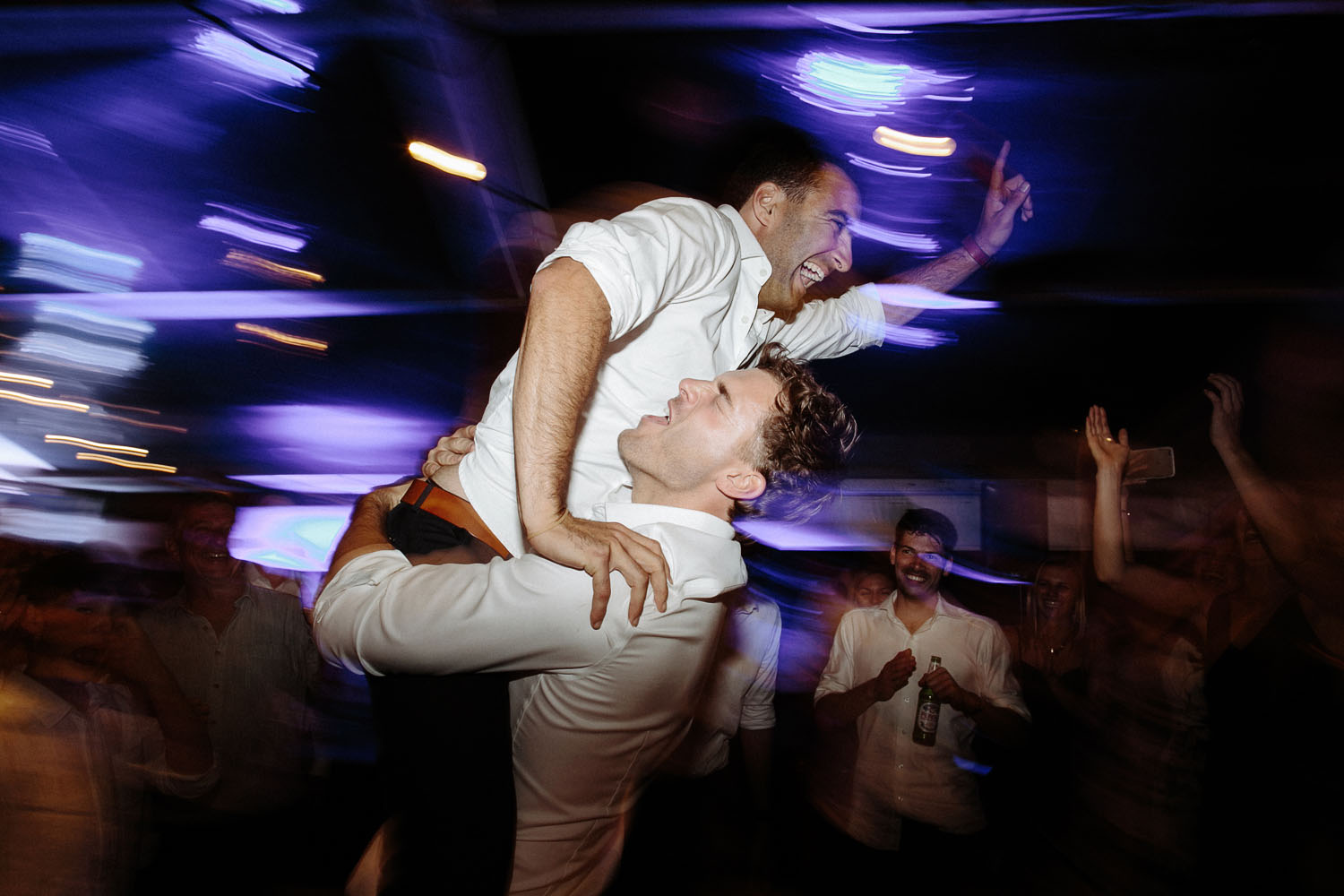 groomsman lifts groom up on dancefloor