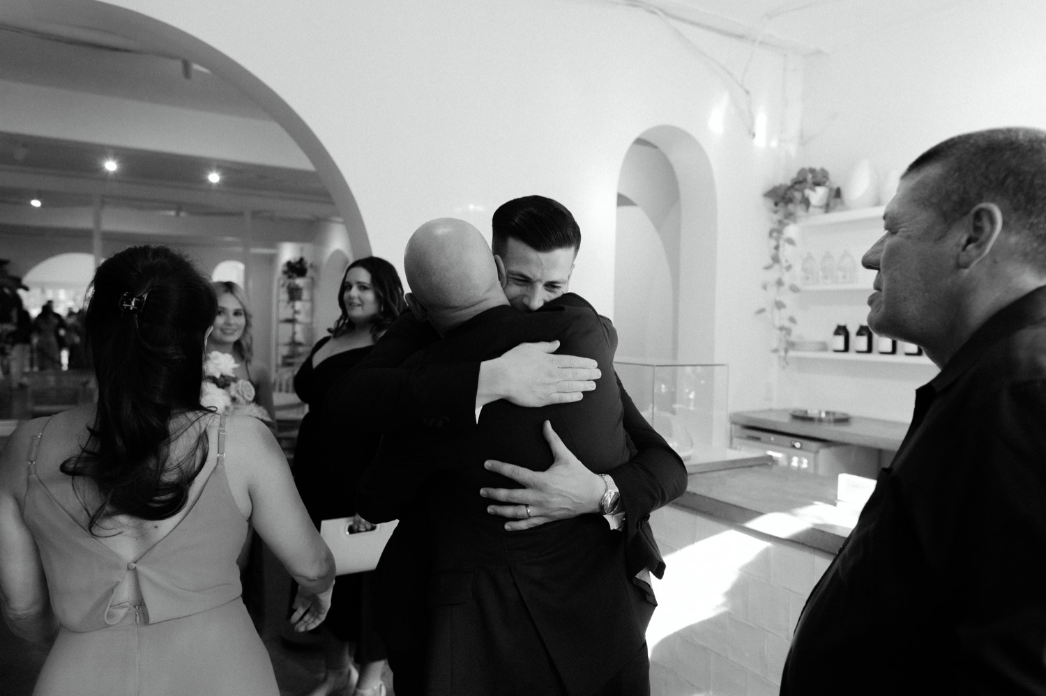 groom firmly hugging guest after ceremony