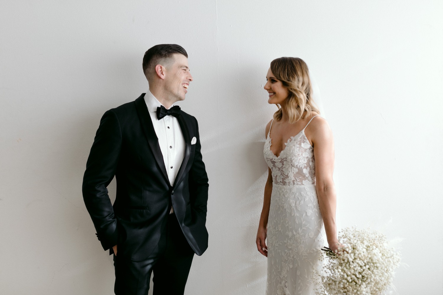 portrait of the bride and groom in black tie laughing