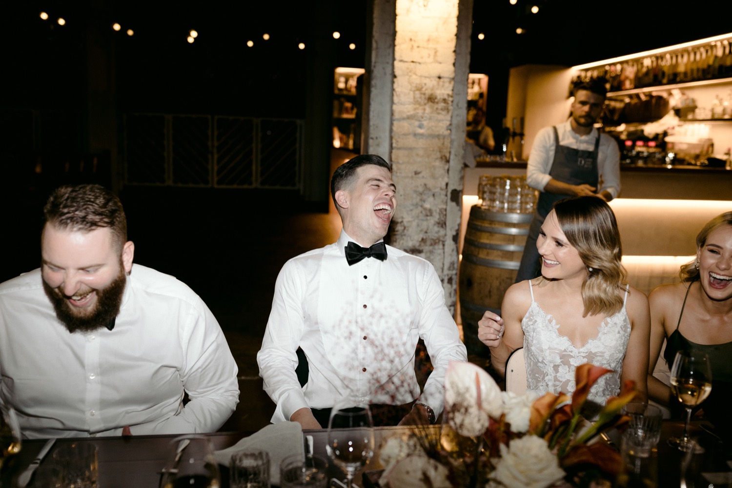 groom laughing in black tie during the speeches