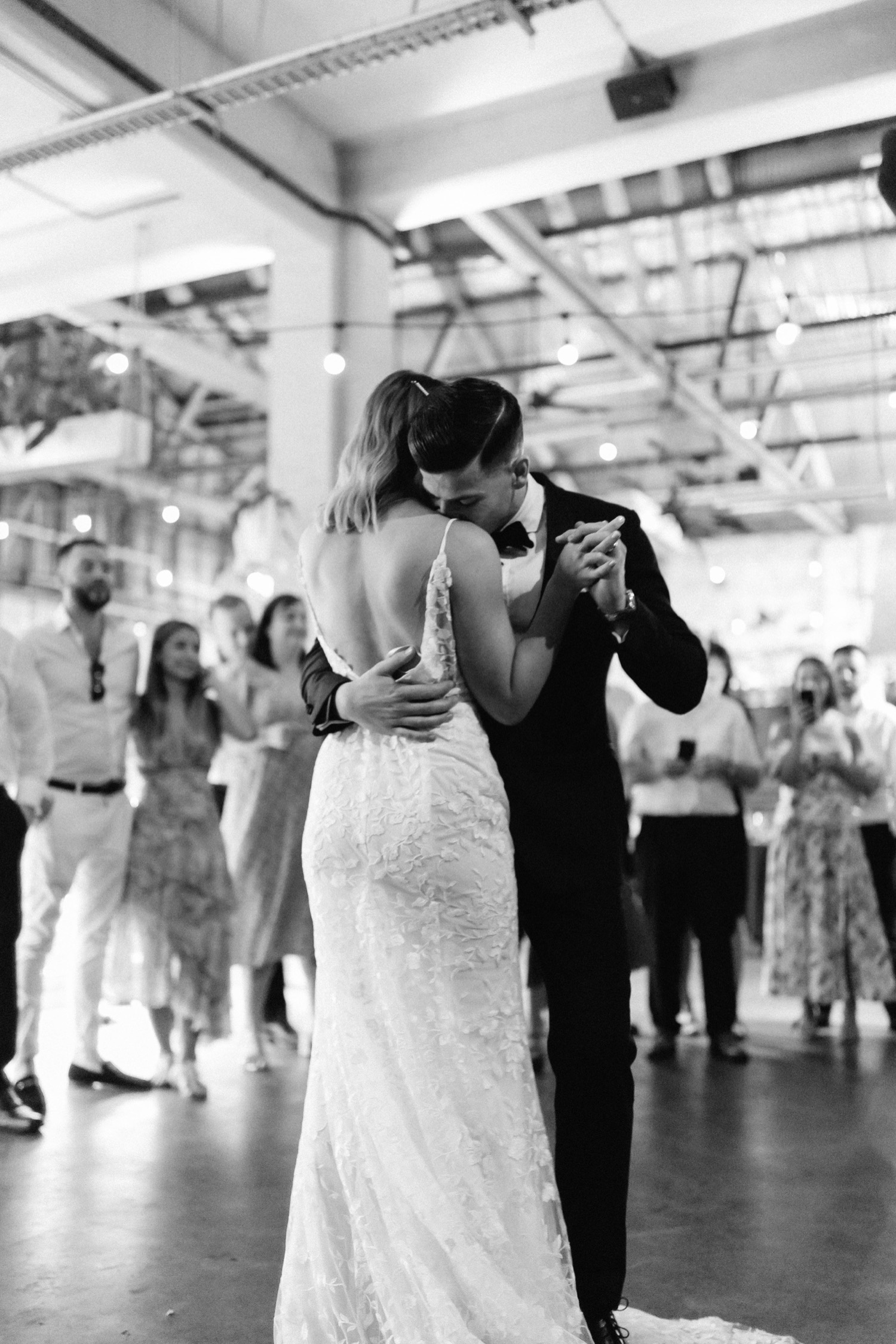groom kissing bride on her shoulder during the first dance