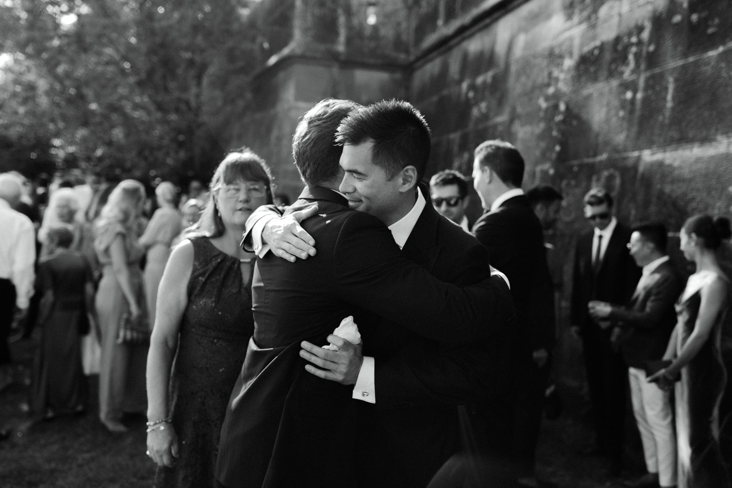 groom hugging wedding guest