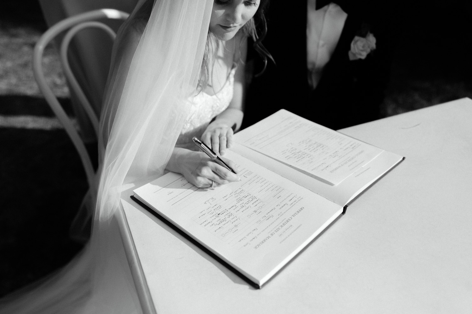 arty shot of bride signing wedding certificate