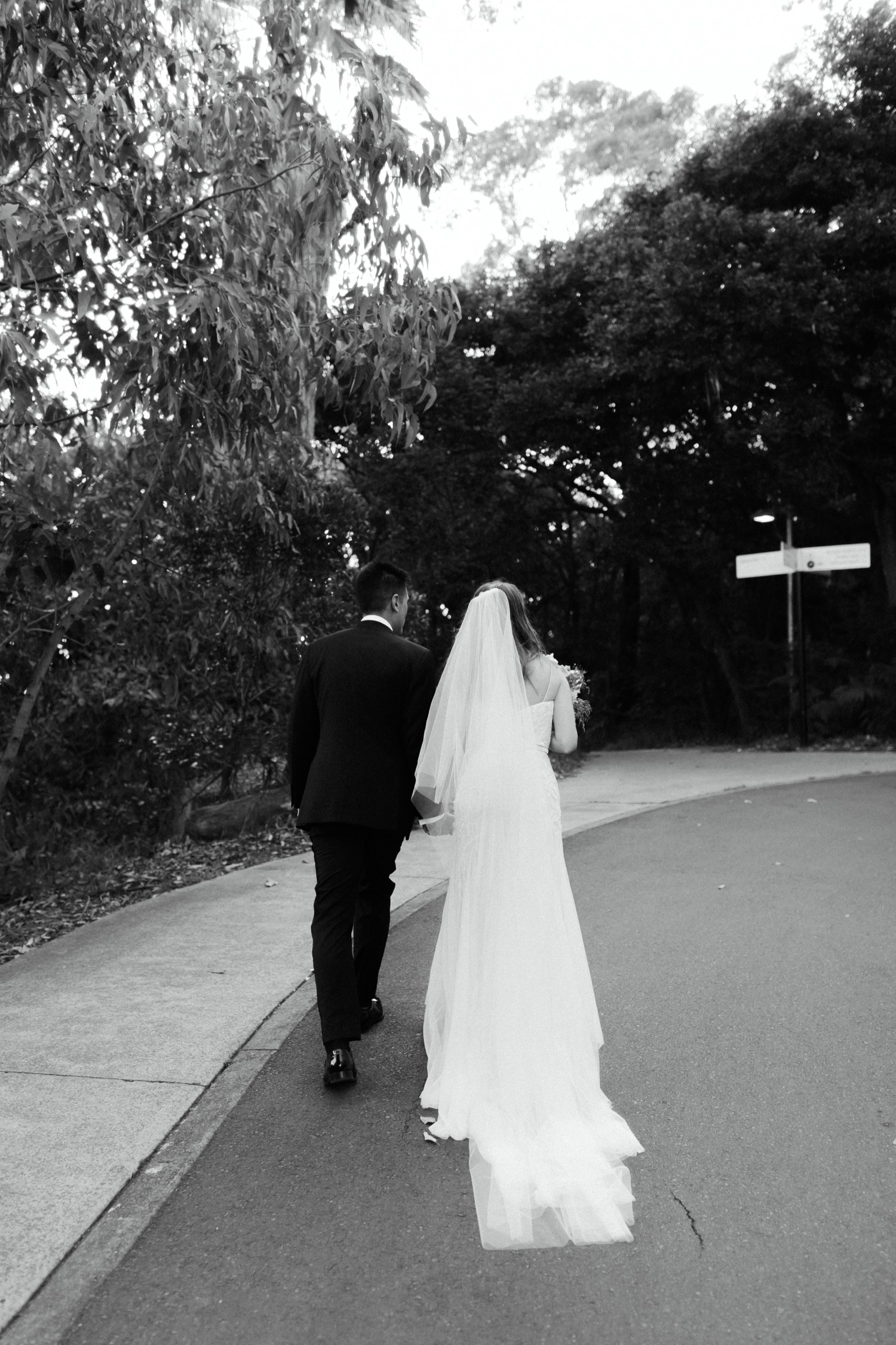black & white shot of bride and groom walking up to georges head